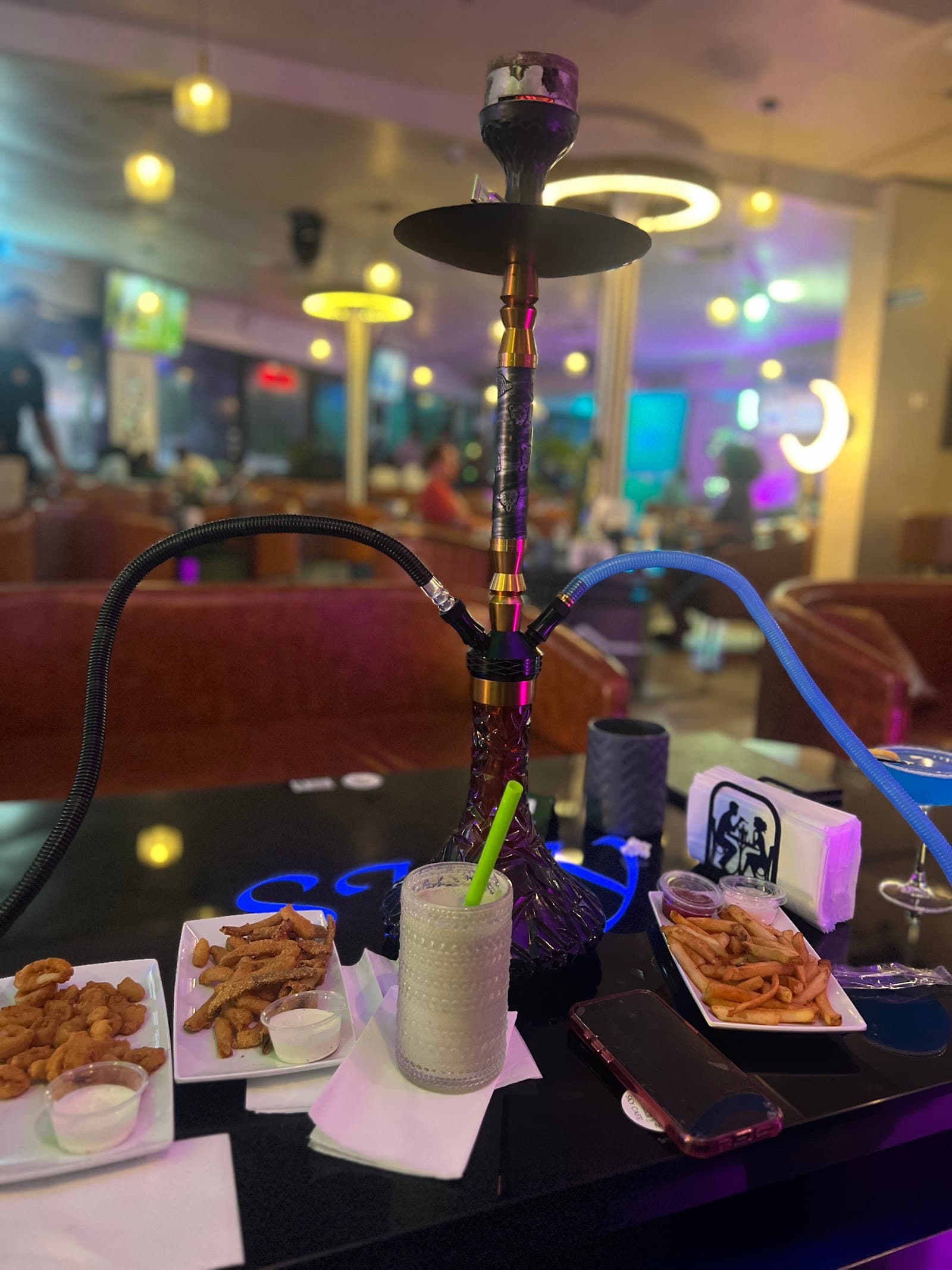 Wings, shrimp, fries and a milkshake alongside a two-hose hookah