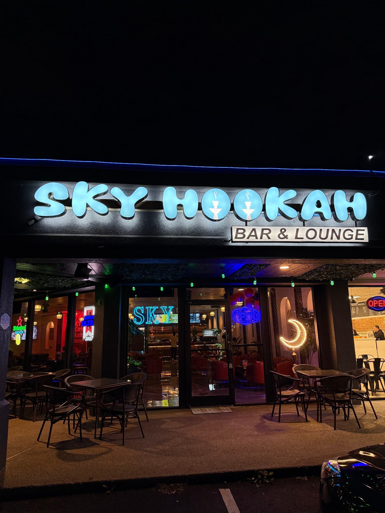 Sky Hookah Bar and Lounge storefront at night, crescent moon glowing in the window